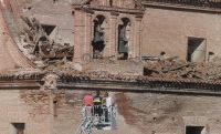 Los técnicos revisan los daños en la cubierta de la espadaña de la iglesia. / FRAN JIMÉNEZ