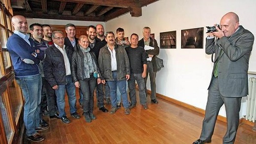 El presidente, Jesús Julio Carnero, fotografía a los autores, rodeados de las imágenes de la muestra ‘Mirada del Alma’, en el claustro del Palacio de Pimentel / LETICIA PÉREZ-ICAL
