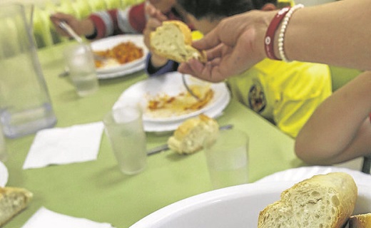Una cuidadora sirve el almuerzo en un comedor. / AFP