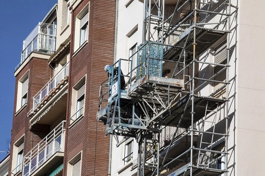 Trabajadores realizan obras de mejora en un edificio residencial en una ciudad castellana y leonesa. - Foto: Óscar Solorzano