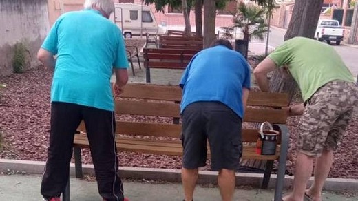 Vecinos de Medina del Campo lijando y pintando los bancos de su barrio / Cadena SER