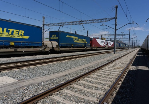 Semirremolques de camiones sobre un tren en una autopista ferroviaria. ADIF